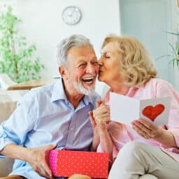 Wife kissing her happy husband after receiving a sweet Valentine's Day present